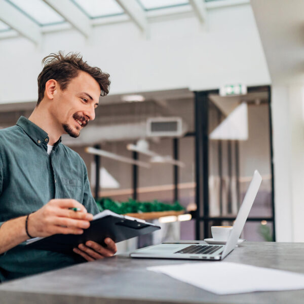 Man at desk with laptop and notepad