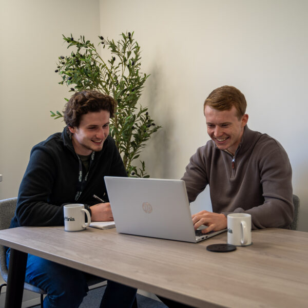 two males looking at laptop at work